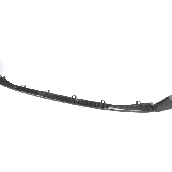 A black car front splitter with a sleek, curved design rests on a plain white background, featuring multiple mounting points along its length.