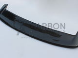 A black carbon fiber car spoiler with a sleek design rests on a plain white background. Text: 