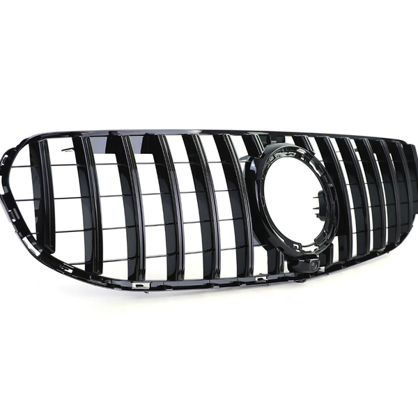 A glossy black car grille features vertical slats and an empty circular emblem holder, set against a plain white background.
