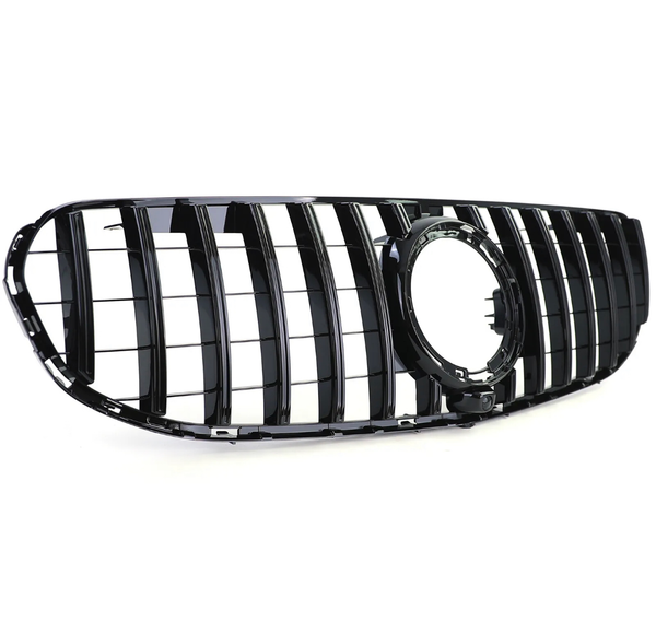 A glossy black car grille features vertical slats and an empty circular emblem holder, set against a plain white background.