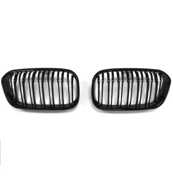 Two black car grilles, each with vertical slats, are positioned side by side against a plain white background.