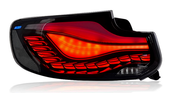 Tail light emits red and orange glow, featuring layered design with intricate patterns. Context shows a labeled blue "OLED" section within a reflective black casing, likely for a car.