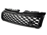 Black car grille with a honeycomb pattern, resting on a plain white surface, featuring a central oval space likely for logo placement, designed for front vehicle installation.