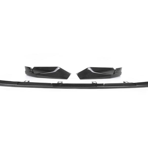 Carbon fiber car splitter and two side fins lie on a plain white background, showcasing their sleek, aerodynamic design intended for automotive performance enhancement.