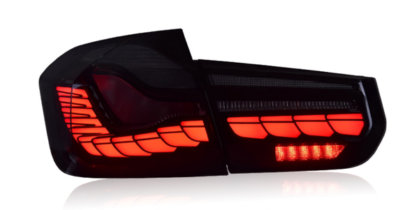 A red LED tail light glows brightly, revealing angular, layered patterns. It is against a plain white background, emphasizing its sleek, modern design.