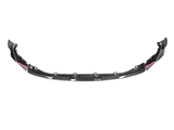 Black carbon fiber car front lip spoiler with aerodynamic design, featuring multiple mounting brackets and red accents. Positioned in a plain white background, highlighting its sleek structure.