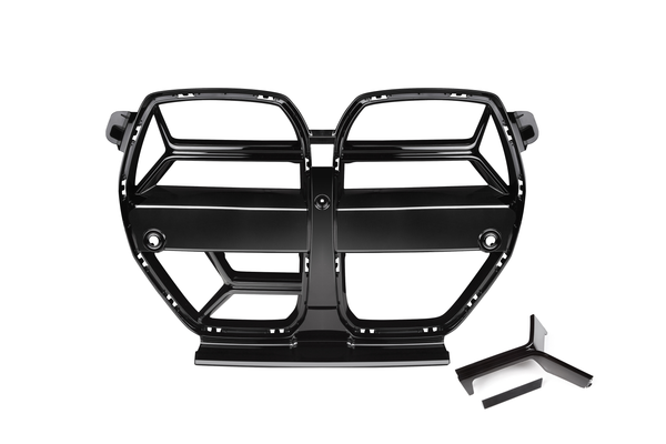 A glossy black car grille with a segmented design rests on a white background, featuring dual openings and two separate black trim pieces nearby.