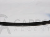A carbon fiber car spoiler, curved and glossy, rests on a plain white surface. Text reads: 