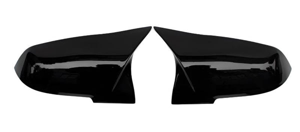 Two glossy black car mirror covers lay side by side on a white background, facing each other symmetrically. They are smooth and have a sleek, aerodynamic design.