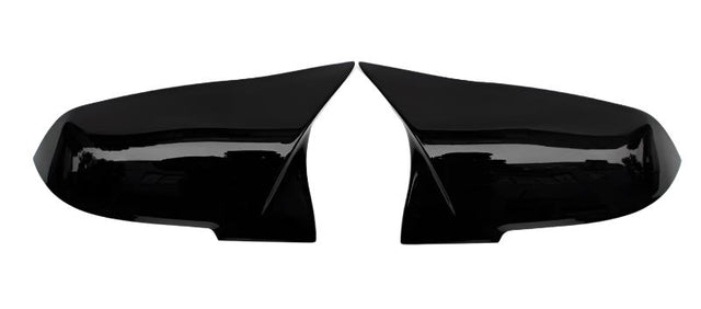 Two glossy black car mirror covers lay side by side on a white background, facing each other symmetrically. They are smooth and have a sleek, aerodynamic design.