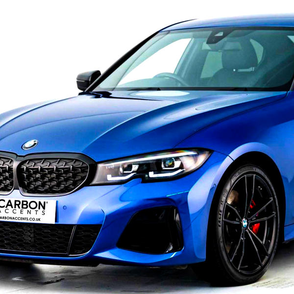 A blue car features a sleek design with black grille and alloy wheels. It is parked on a white background. The license plate reads: "CARBON ACCENTS www.carbonaccents.co.uk".