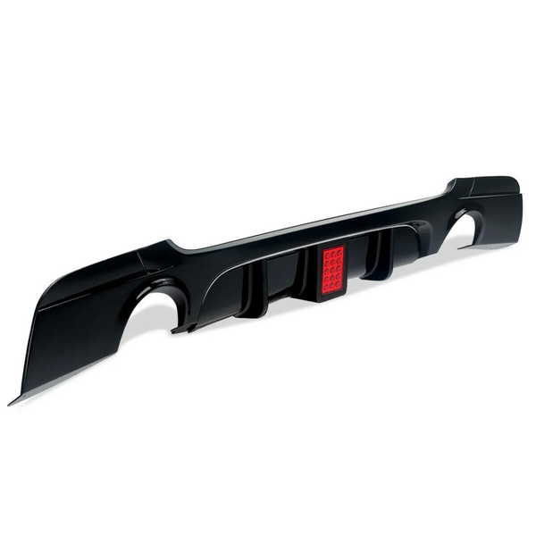 A black car rear diffuser with aerodynamic fins features a central red light, sitting isolated on a plain white background.