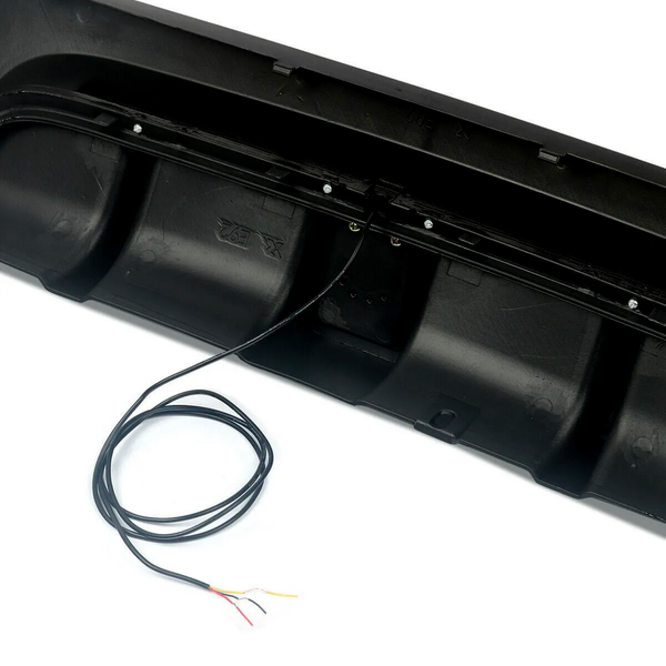 A black plastic automotive grille panel with an attached black wire exits the panel, showing exposed, multicolored ends against a plain white background.