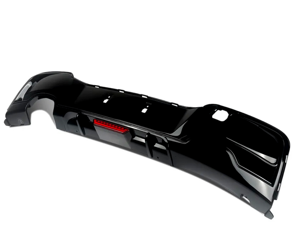 A black car bumper with a central red reflector sits isolated on a white background, featuring cutouts for attachment and a sleek, aerodynamic design.