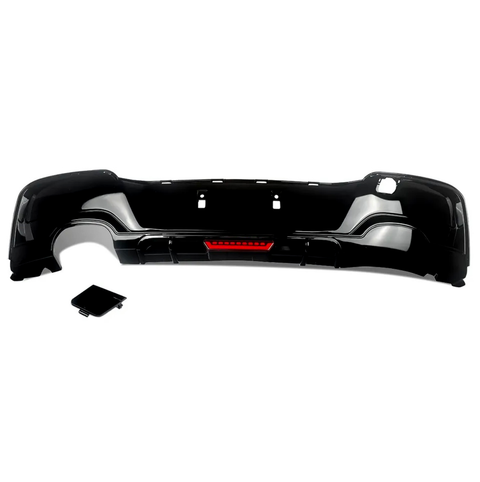 Black car bumper with a red reflector section, placed on a white background. A separate, matching black rectangular piece lies nearby, possibly a cover or attachment.