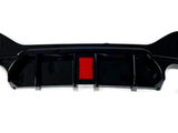A black car bumper with a central red reflector is displayed against a white background, showcasing its aerodynamic design and sleek features.