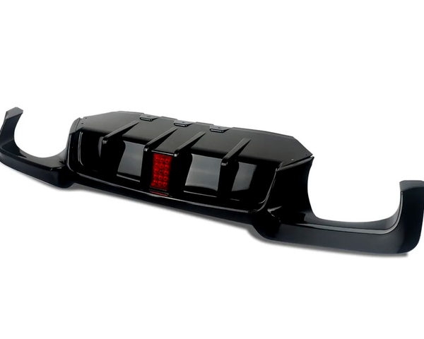 A black car rear diffuser with aerodynamic fins and a central red reflector, designed for enhancing vehicle performance, shown isolated against a plain white background.