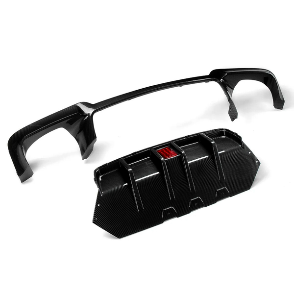 Carbon fiber car spoiler and diffuser resting separately, with the diffuser featuring a central red reflector; placed on a plain white background.