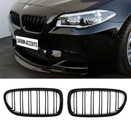 A black car front features a sleek kidney grille, with the text "CARBON ACCENTS" on a license plate. Below, two grille inserts are shown separately on a white background.