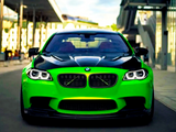 A bright green BMW car with black accents is parked on a street. Surrounding it are modern buildings and a partly cloudy sky in the background.
