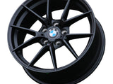 A black, multi-spoke BMW wheel rim with visible lug holes and a 