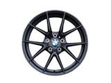 A black alloy wheel displaying the BMW logo is positioned centrally. Text 