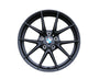 A black alloy wheel displaying the BMW logo is positioned centrally. Text "M PERFORMANCE" is etched on the rim. The wheel spokes radiate outward, isolated on a plain white background.