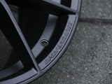 A black wheel rim features embossed text 