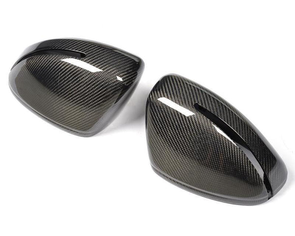 Two black carbon fiber car mirror covers with a sleek, glossy finish, positioned side by side, against a plain white background.