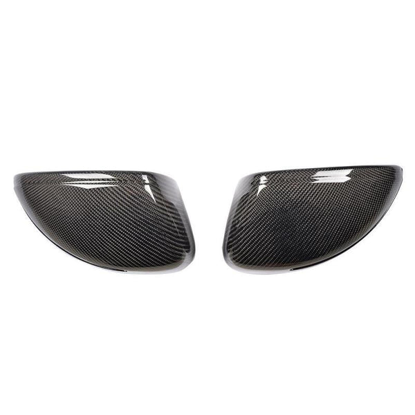 Two carbon fiber mirror covers are positioned side by side, displaying a smooth, reflective surface with a distinct woven pattern. The white background accentuates their sleek design.