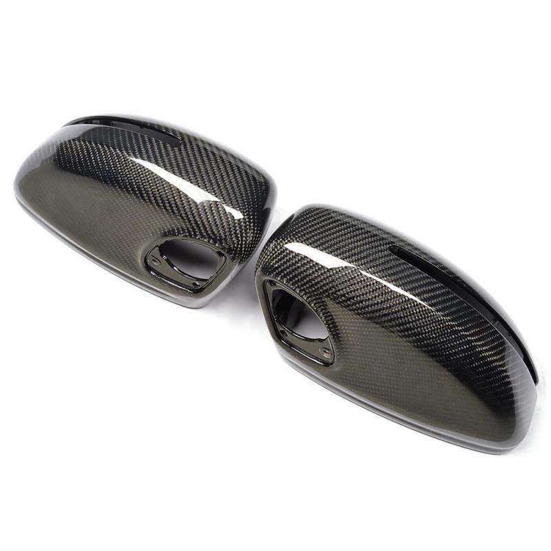 Two glossy carbon fiber side mirror covers rest on a white background, showcasing a sleek, modern design with visible weave patterns and mounting holes.