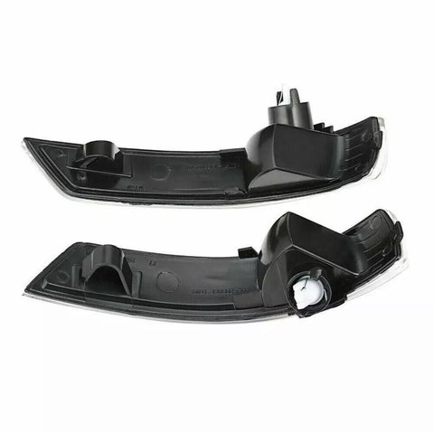 Two black car mirror indicators, each with a sleek curved shape and mounting clips, lie against a white background, showcasing their design and structure for automotive use.