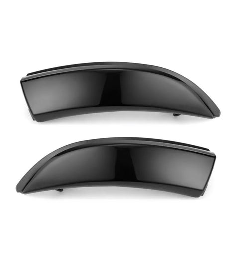 Two sleek, black car fender flares are displayed horizontally against a plain white background, highlighting their smooth, curved design and glossy finish.