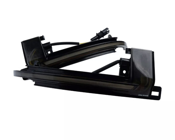 A sleek black automotive light fixture with wiring, labeled "AMG RGNG," against a white background, showcasing its angular design and curved edges.