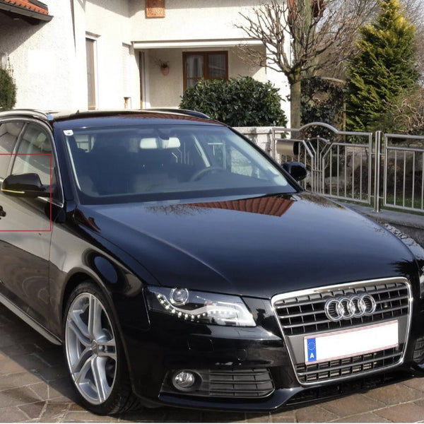 A black car is parked on a driveway outside a house, with a red rectangle marking the driver's side window and mirror. There’s a stone fence and greenery nearby.