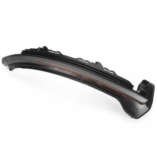 Curved black plastic car part with amber lens detail, likely a turn signal light, on a white background.