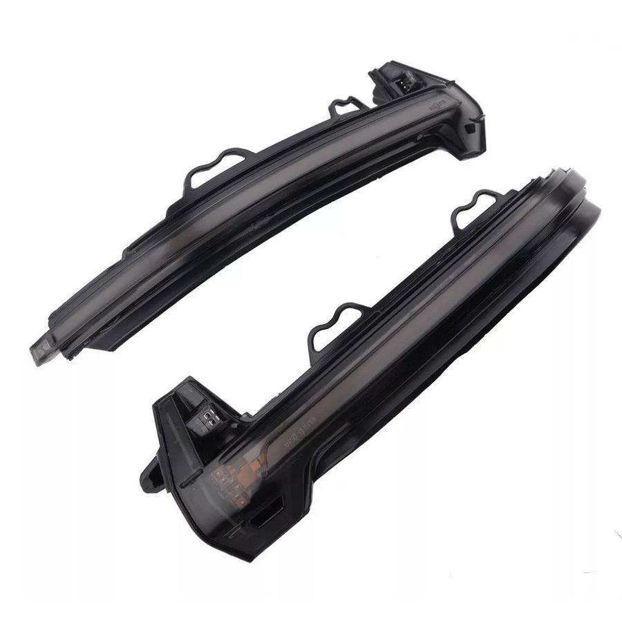 Two curved black plastic car mirror covers with integrated LED turn signals lie against a plain white background, showcasing openings and connectors for installation.