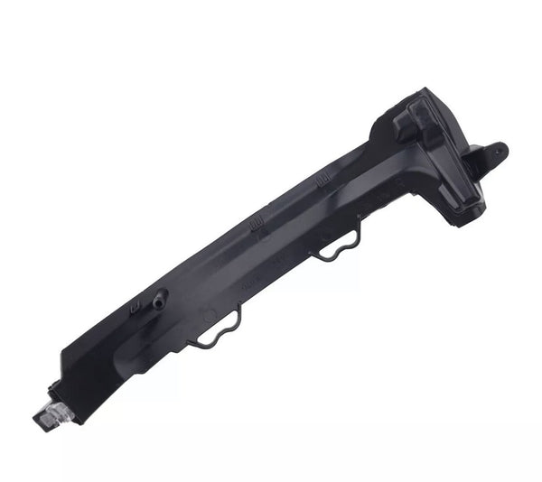 A black, angular plastic car component with multiple ridges and mounting points, possibly a bumper bracket, rests against a plain, white background.