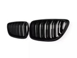 A pair of shiny, black car grilles with vertical slats are displayed against a plain white background, emphasizing their sleek, modern design.