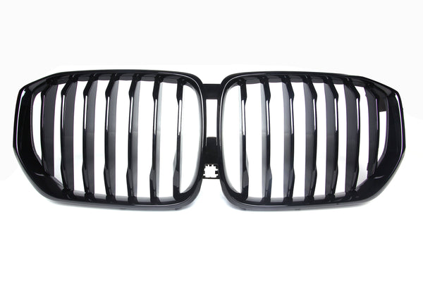 A shiny black car grille with vertical slats, forming two adjacent kidney-shaped sections, set against a plain white background.