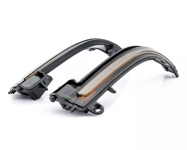 Curved LED light strips rest on a white surface, featuring sleek black casings and a translucent cover, commonly used in automotive signals or indicators for enhanced visibility.