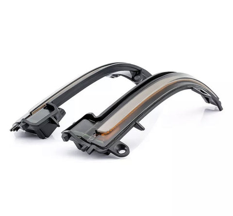 Curved LED light strips rest on a white surface, featuring sleek black casings and a translucent cover, commonly used in automotive signals or indicators for enhanced visibility.