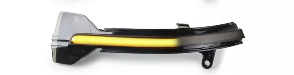 A sleek, curved car turn signal light illuminates in a bright yellow. The light is enclosed in a black and transparent casing, set against a plain white background.