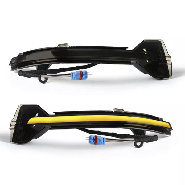 Two car side mirror indicators, one outlined with a yellow strip, display wiring connectors. They are positioned on a white background, highlighting their curved design and blue connectors.