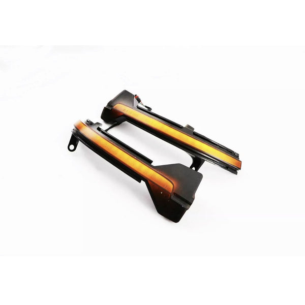 Two sleek, black-and-orange automotive parts with integrated wiring lie on a plain white surface, likely designed as LED light strips or indicators for vehicle installation.
