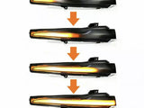 Four sequential images of a car turn signal light with an orange LED strip gradually illuminating from left to right. Each image is separated by a downward orange arrow.