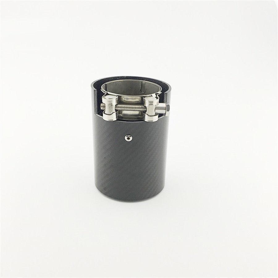 A cylindrical metallic exhaust tip with a carbon fiber exterior and clamp mechanism is placed upright on a plain white surface.