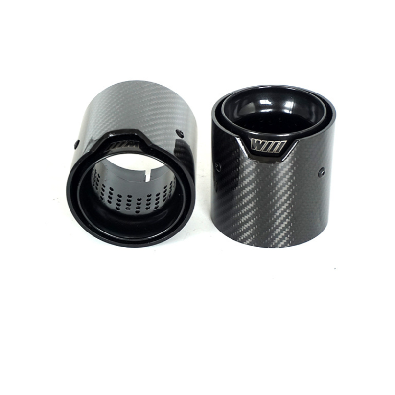 Two carbon fiber cylindrical exhaust tips are positioned upright and slightly angled against a white background. Each has a visible perforated inner surface; one displays the text "WIII" on its edge.
