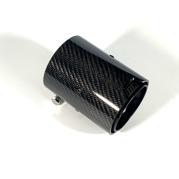 A cylindrical carbon fiber exhaust tip with a shiny black finish rests on a white background. It features small screws for attachment.