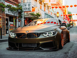 A sleek, customized BMW with lowered suspension parked on a street in Chinatown, surrounded by traditional architecture and red lanterns, creating a vibrant, urban setting.